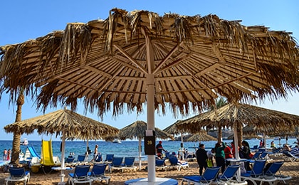 Немноголюдный пляж Шарм-эль-Шейха в январе с лежаками и зонтиками