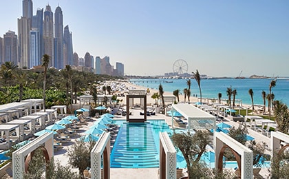 Пляжная зона Джумейра Бич Резиденс с небоскребами и зонтиками для пар в Дубае