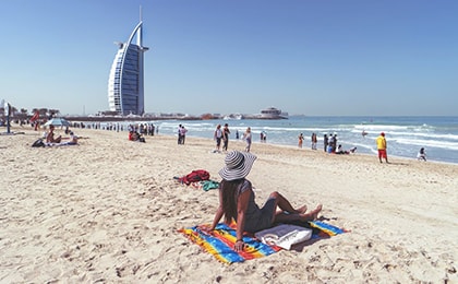 Общественный пляж Джумейра с видом на отель Burj Al Arab и отдыхающими на песке