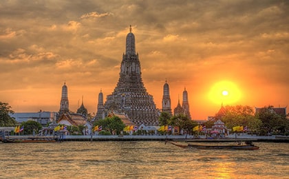 Храм Утренней зари Ват Арун на реке Чао Прайя в Бангкоке — буддийская святыня с мозаичными башнями